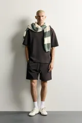 Bermuda estilo jogger de ajuste relajado, confeccionada en tejido interlock de algodón. Cuenta con cintura elástica ajustable con cordón, bolsillos frontales de vivo y diseño liso.