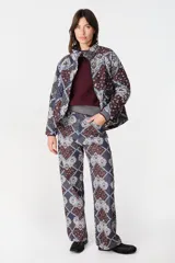 Pantalon de pierna recta con estampado tipo patchwork en tonos azul, bordó y blanco. Cuenta con cintura ajustable con elástico y cordón, dos bolsillos laterales redondeados y dos bolsillos traseros tipo plaqué.