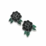 Set de dos pins: uno con forma de rosa en color crema con contorno negro y otro con forma de tigre dorado.