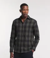Camisa de hombre de manga larga, confeccionada en franela de algodón, con cuello inglés y abotonadura frontal. Presenta un estampado de cuadros grandes en tonos verde oliva y negro.