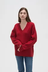 Sweater de punto con diseño de ochos, color rojo, con cuello en V y mangas largas de corte holgado.