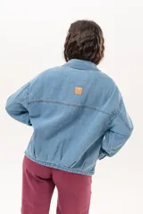 Campera de jean color celeste con silueta relajada y calce amplio. Presenta cierre frontal metálico, cuello clásico y bolsillos laterales.