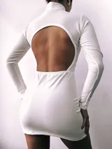 Minivestido blanco de mangas largas con cuello alto y espalda descubierta.