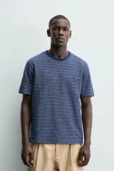 Camiseta de corte regular con cuello redondo y manga corta, confeccionada en tejido jacquard con diseño de rayas horizontales finas en azul marino y blanco.