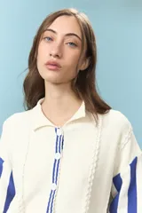 Cardigan de algodón color azul con mangas largas de rayas verticales anchas en tonos azul y celeste, puños en rojo, y bordado en la espalda con diseño de escudo nacional.