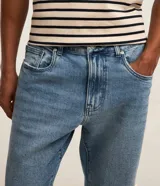 Pantalón de jeans denim celeste, corte slim, con cintura fija con trabillas, bolsillos y pespuntes.