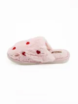 Pantuflas de peluche color blanco con estampado de corazones rojos, diseño abierto y suela plana.