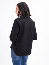 Camisa blanca de manga larga, con cuello clásico y cierre frontal de botones.