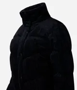 Campera puffer de mujer con diseño acolchado y textura acanalada tipo cotelé. Presenta cuello alto, cierre frontal con botones a presión y puños elásticos.