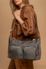 Bandolera de tafeta impermeable color beige, con dos bolsillos frontales con cierre y correa regulable. Diseño práctico y liviano ideal para uso diario.