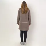 Tapado de textura tipo corderito en color taupe, con diseño de corte recto y largo. Presenta detalles de paneles lisos en los laterales y en las mangas, cuello con solapas y cierre frontal.