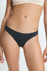 Bombacha tipo vedetina de color negro con estampado de pequeñas estrellas y lunas blancas. Confeccionada en poliamida y elastano con forro de algodón.