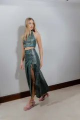 Falda midi de cuero ovino color verde azulado con efecto desgastado. Presenta tajo lateral con cordones cruzados.