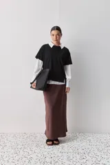 Remera de manga corta negra de algodón, con silueta relajada, cuello redondo y tajos laterales.