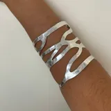 Brazalete plateado con diseño calado.