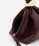 Bolso tipo bucket pequeño color marrón oscuro, confeccionado en material sintético con poliéster certificado. Tiene correa de mano y detalle de metal dorado.