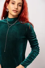 Polera de manga larga color verde petróleo con detalle de drapeado en las mangas. Confeccionada en terciopelo velvet con lurex.