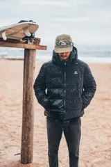 Campera puffer con capucha, color negro, con cierre frontal y diseño acolchado. Presenta un acabado con efecto mojado y logo pequeño en el pecho.