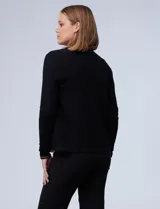 Cardigan tejido negro con ribete de cadena dorada.