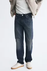 Pantalón jean de cinco bolsillos en denim de algodón con lavado azul oscuro, cintura clásica y corte de pierna recta.