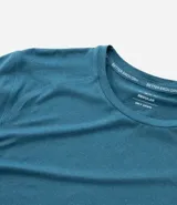 Remera deportiva de hombre con tecnología dry fit, cuello redondo y manga corta. Presenta un diseño liso en color beige con una pequeña etiqueta decorativa en el dobladillo.