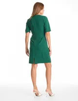 Vestido midi de crepe color verde, con cuello a la base y detalle de escote entrelazado. Presenta mangas cortas, cierre invisible en la espalda y tajo en el ruedo.