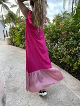 Vestido largo de fibrana fucsia con volado rosa en el ruedo y tiras finas que se atan en los hombros.