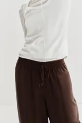 Pantalón de tiro medio con cintura elástica ajustable con cordón. Presenta un diseño de paneles laterales en tejido técnico contrastante y bolsillos tipo cargo. Su corte es holgado con pernera que se estrecha hacia el tobillo.