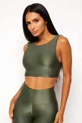 Top deportivo color terracota, de corte crop y manga sisa, con cuello redondo y espalda escotada. Presenta textura acanalada y acabado brillante.