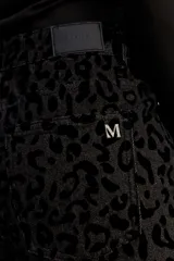 Jean de corte wide leg y tiro medio, confeccionado en algodón con estampado animal print en tonos negros. Presenta un diseño de pierna amplia y cierre frontal con botón y cremallera.