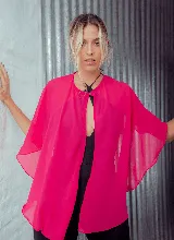 Capa corta color fucsia de gasa, estilo torerita, con mangas amplias y abertura frontal.