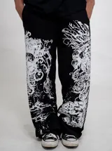 Jogging negro baggy con estampado serigrafiado en blanco en ambas piernas, cintura elástica y corte holgado.