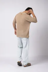 Camisa de punto calado en color beige, de manga corta y corte relajado. Presenta cuello tipo bowling, cierre frontal con botones al tono y una estructura liviana y respirable confeccionada en algodón.