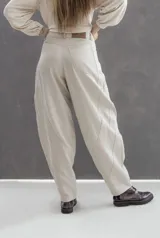 Pantalón de gabardina de algodón suavizada con corte bagui balloon, presenta detalle de cortes en forma de medialuna en la parte trasera con pespuntes en contraste, doble bolsillo superpuesto, cierre de metal y botón metálico con logo de la marca.