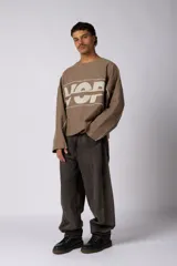 Buzo oversize de corte boxy, confeccionado en algodón rústico de alto gramaje en color beige. Presenta cuello redondo con borde crudo, mangas largas y una estampa frontal con el texto VCP delimitado por líneas horizontales blancas.