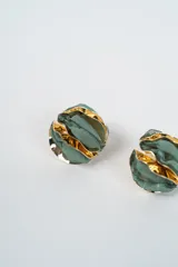 Aros de diseño circular con capas alternas de tela marrón y láminas metálicas doradas, creando un efecto de volumen y textura.