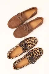 Mocasín tipo boat shoe color marrón, confeccionado en cuero, con cordones de cuero marrón y cordones decorativos azules.