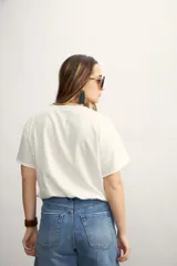Blusa blanca con diseño cruzado, escote en V y mangas cortas.