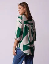 Camisa de manga larga con estampado abstracto en tonos verde y blanco. Cuello con solapa y abertura central con botones. Largo de manga regulable con presilla y botón. Terminación de ruedo anudada opcional.