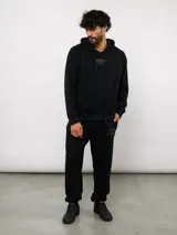 Pantalón jogger de felpa sin frisa, color gris claro melange, con logo bordado de Umbro en azul oscuro en el muslo izquierdo y puños elásticos en los tobillos.