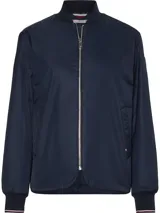 Campera bomber azul marino de poliéster reciclado, con cuello estilo béisbol, cierre de cremallera, puños y cuello de punto canalé, dos bolsillos diagonales en la cintura y detalles distintivos de Tommy Hilfiger.