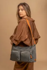 Bandolera de tafeta impermeable color beige, con dos bolsillos frontales con cierre y correa regulable. Diseño práctico y liviano ideal para uso diario.