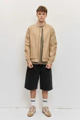Campera bomber de gabardina color tostado, con cierre frontal y bolsillos laterales, puños y cintura elastizados de rib.