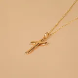 Conjunto compuesto por una cadena de eslabones finos y un dije de cruz clásica, ambos realizados en oro 9k con acabado pulido.