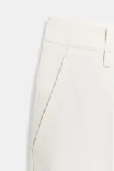 Pantalón de corte recto confeccionado en algodón, con tiro medio y cintura con trabillas. Presenta bolsillos laterales, bolsillos de vivo en la parte trasera y detalle de raya planchada en el frente. Cierre frontal con cremallera, botón y ganchos metálicos.