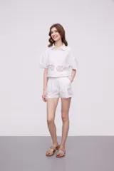 Short blanco de algodón con cintura elástica y detalles de encaje crochet en los laterales y el ruedo.