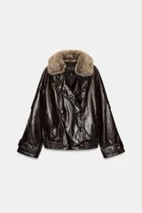Chaqueta de efecto cuero con acabado brillante, cuello de solapa con aplicación de pelo sintético extraíble, cierre frontal cruzado con botones, mangas largas con puños ajustables y bajo elástico. Cuenta con forro interior acolchado.