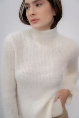 Polera gris de tejido de punto grueso, con cuello alto y mangas largas.