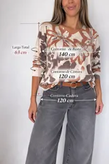 Tejido fino de media estación con estampado floral tipo print en tonos beige y marrón, con aplicaciones de strass que forman tréboles y la palabra "LOVE". Presenta cuello en V y manga larga.