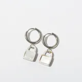 Par de aros argolla plateados con dije colgante en forma de candado con frente de nácar.